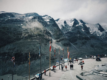 People walking on snowcapped mountain against sky