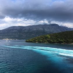 Scenic view of sea and mountains against sky