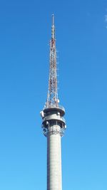 Low angle view of communications tower against clear blue sky