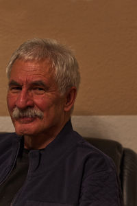 Portrait of man smiling against wall