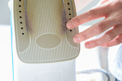 Close-up of woman touching iron