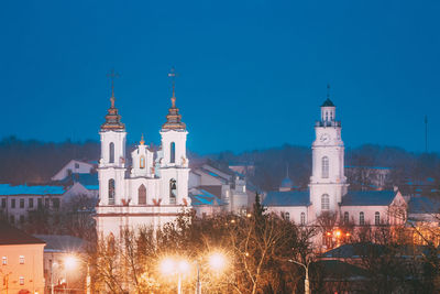 Illuminated building against blue sky at night