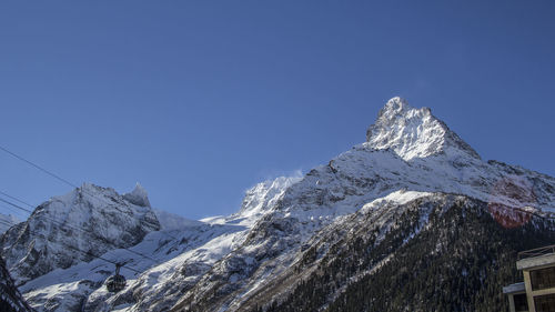 Scenic view of snowcapped mountains against blue sky