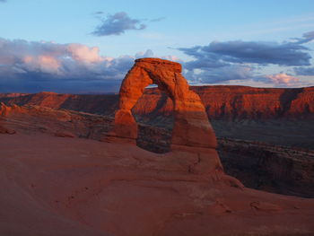 Rock formations on landscape against cloudy sky