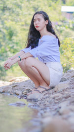 Young woman sitting on rock