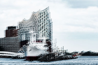 Ship moored at harbor against sky