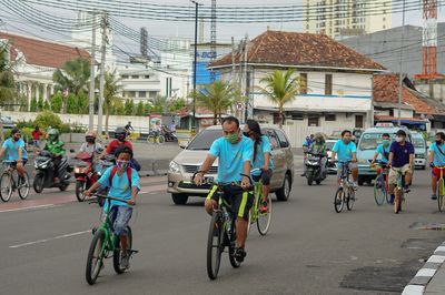 People riding bicycles on road in city