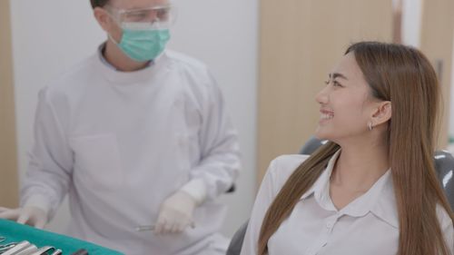 Side view of female doctor examining patient at clinic