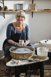 Potter making bowl on wheel. self-employed pottery artist in creative studio working with raw clay