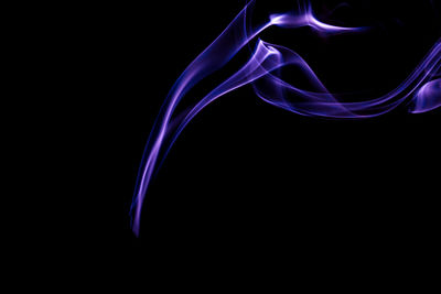 Close-up of purple smoke against black background