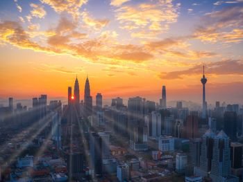 Aerial view of buildings in city during sunset