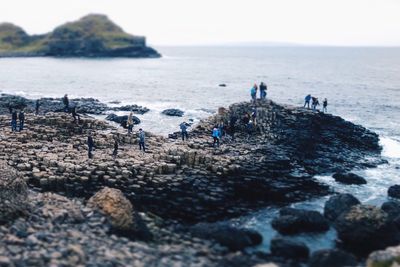 Tourists on beach against sky