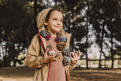 Portrait of smiling woman standing against trees