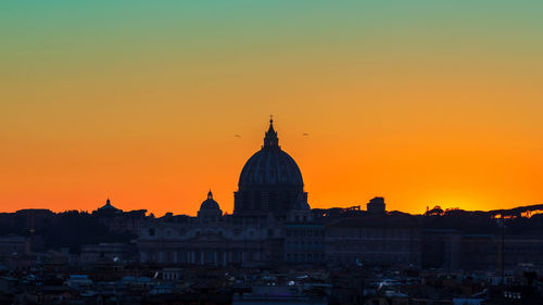 Sunset on the skyline of rome city, with the dome of st. peter's cathedral in the center. 