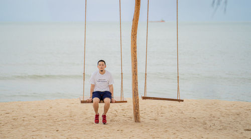 Full length of man standing on beach against sky