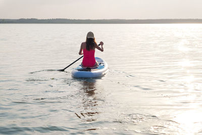 Rear view of man kayaking in sea