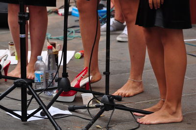 Low section of singers standing near microphone stand on street