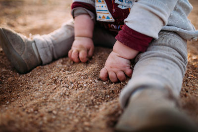 Low section of baby playing at beach