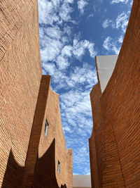 Low angle view of buildings against cloudy sky