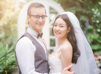 Loving wedding couple standing at backyard