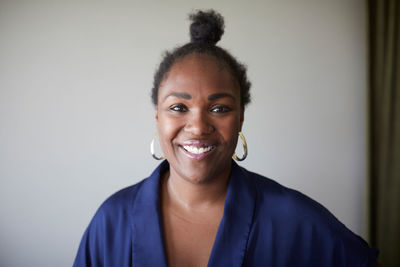 Portrait of confident creative businesswoman standing against gray wall in office