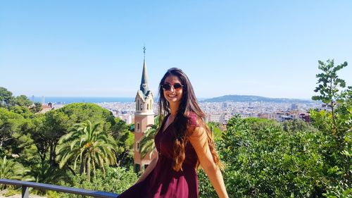 Portrait of smiling young woman against clear sky