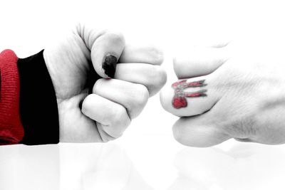 Midsection of couple holding red hands