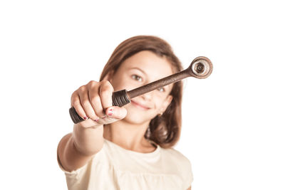 Close-up portrait of young woman holding camera over white background