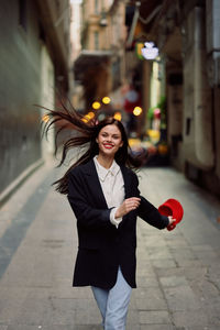 Portrait of young woman standing on street