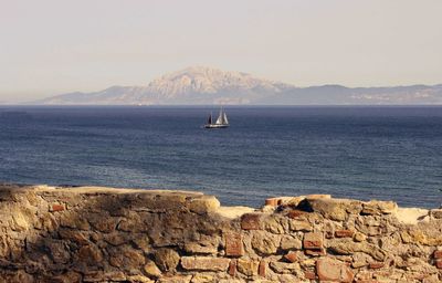 Sailboat sailing on sea against sky