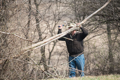 Full length man chopping down tree