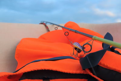 Close-up of orange hanging on rope against sky