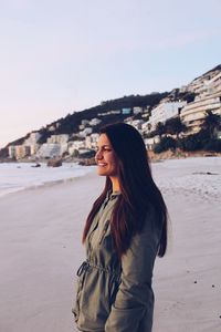 Beautiful young woman standing on beach