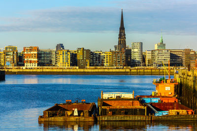 Commercial dock in river with cityscape in background