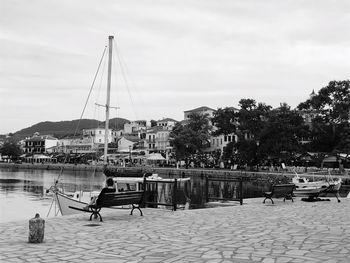 People sitting on riverbank against sky