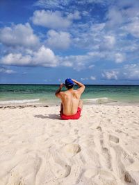 Rear view of shirtless man on beach