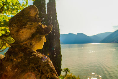 Close-up of statue by sea against sky