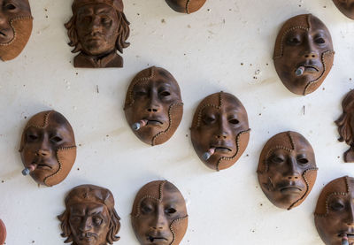 Brown masks with cigars mounted on wall