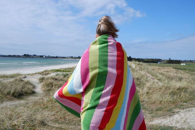 Rear view of woman standing on beach