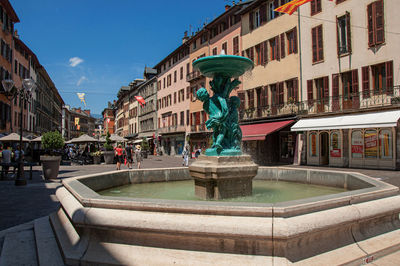 Square with buildings and fountain at the city center of chambery, france.