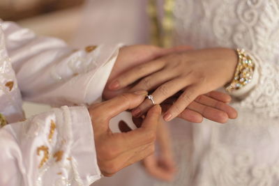 Midsection of bride holding wedding dress