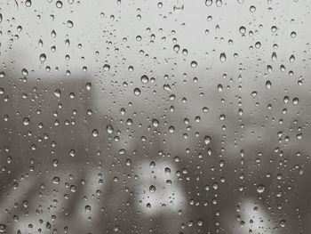 Close-up of waterdrops on glass against blurred background