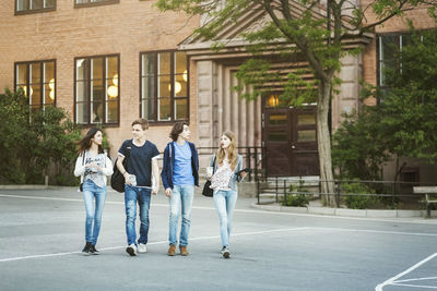 Friends talking while walking on street outside building