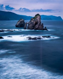 Scenic view of rocks in sea against sky