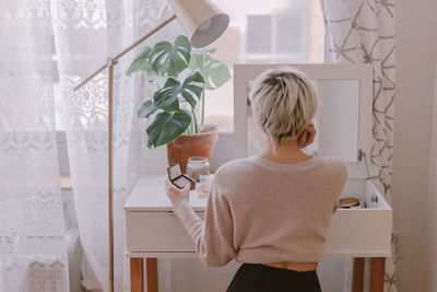 Rear view of woman standing at home