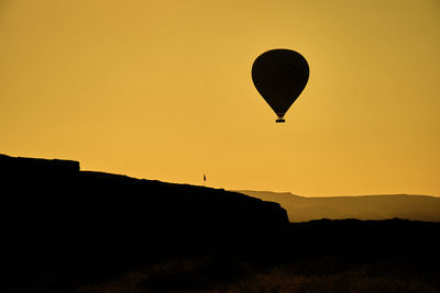 Silhouette of hot air balloon against sky during sunset