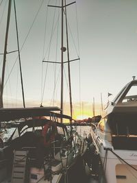 Boats moored in sea against sky during sunset