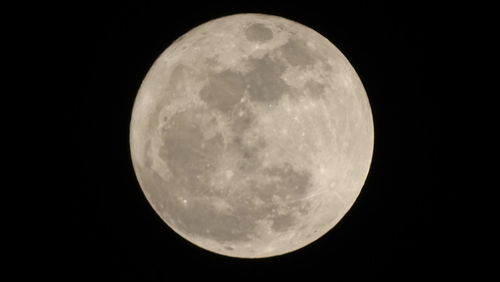 Low angle view of full moon against clear sky at night