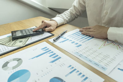 Midsection of businessman working over graph in office