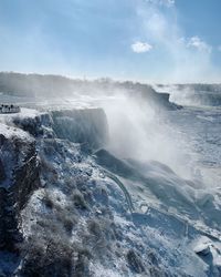 Scenic view of waterfall against sky during winter